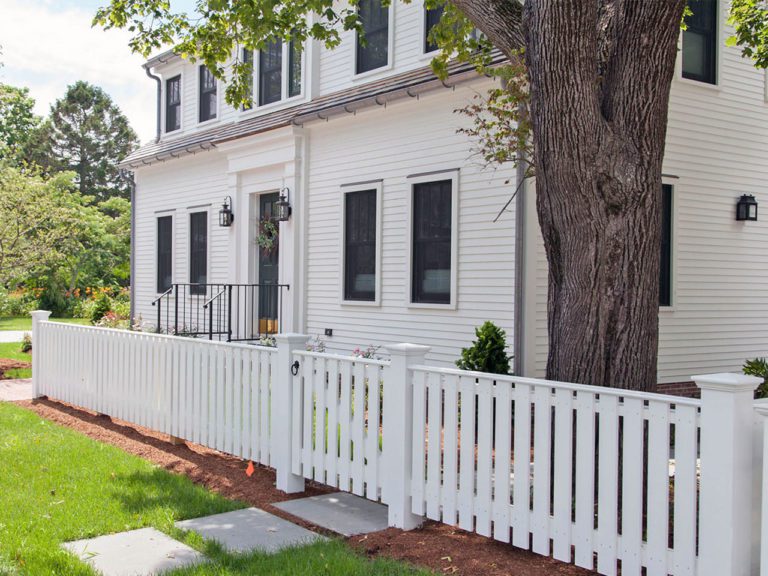 white spaced picket fence in front of a historic home