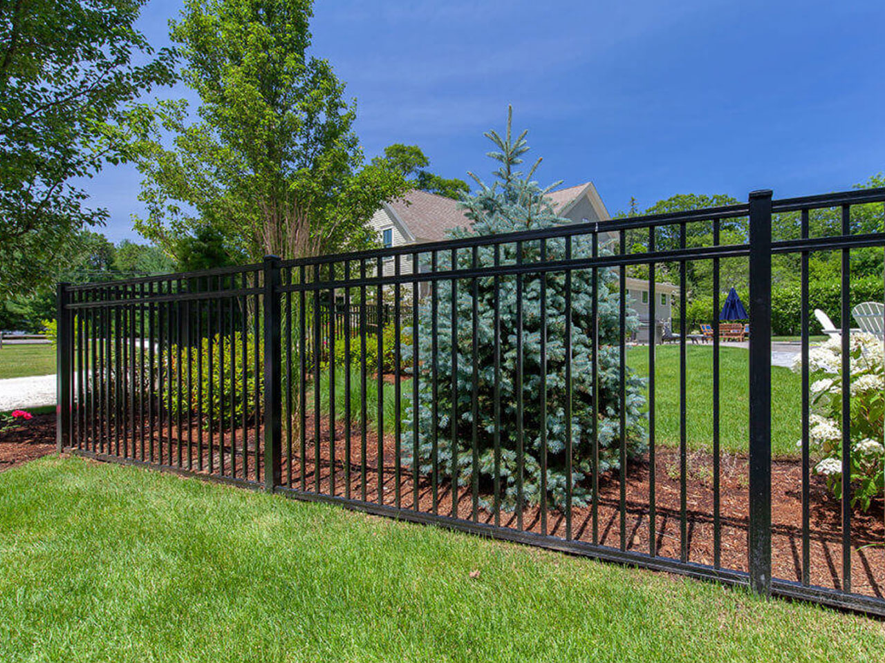 black aluminum fencing around a yard surrounded by trees